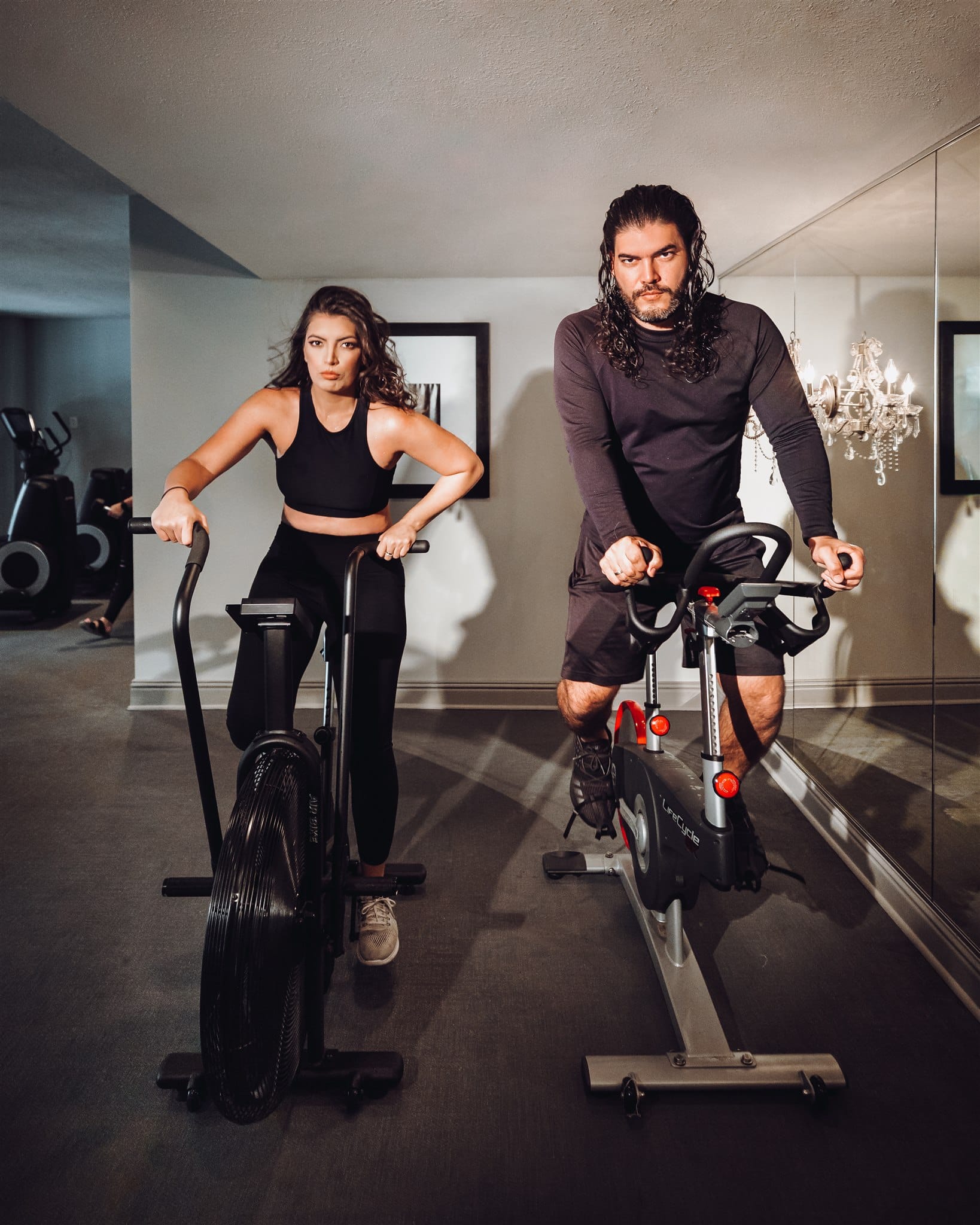 Woman and man on gym spin bikes